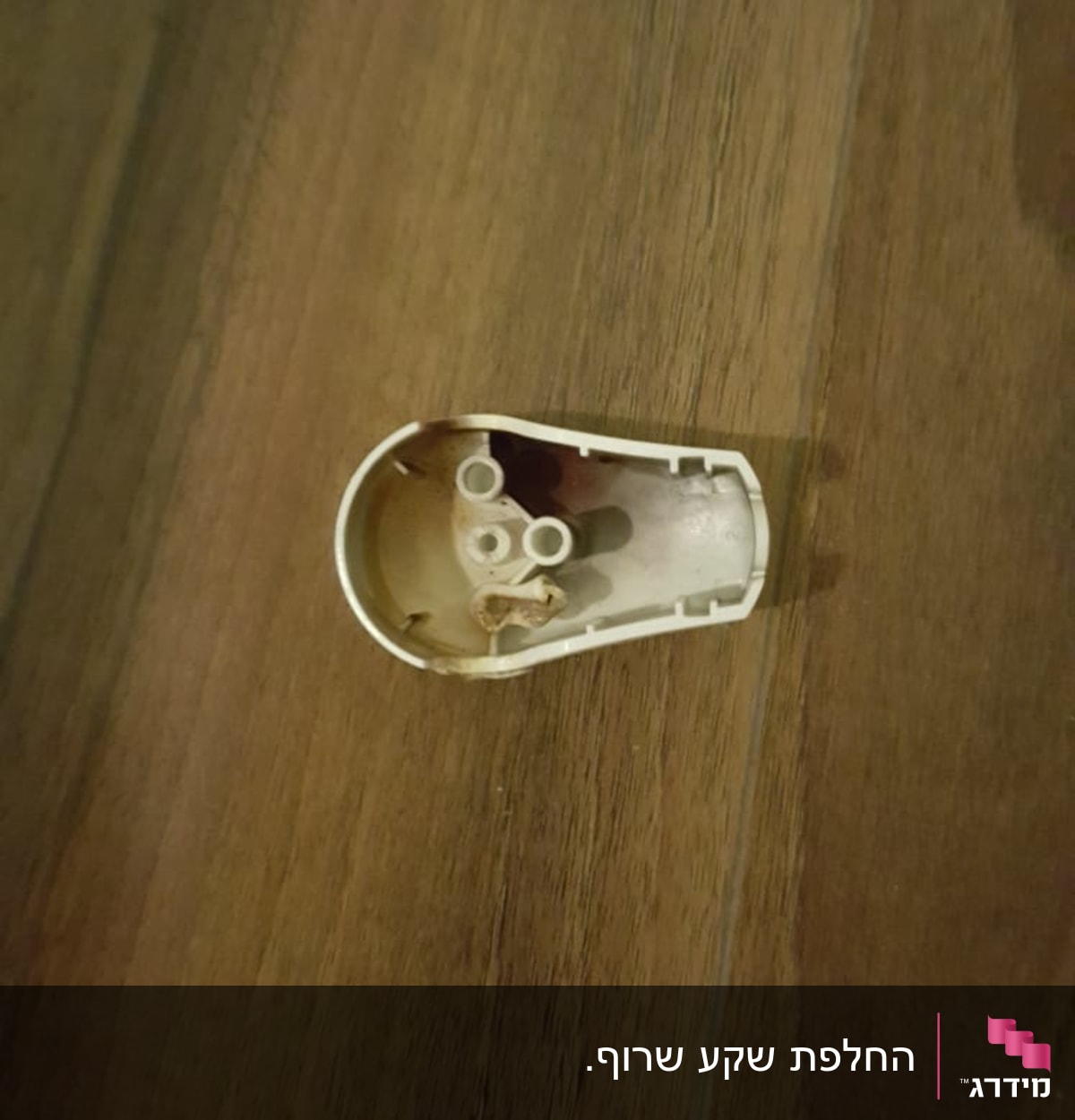 חלק פלסטיק של תקע חשמלי על שולחן עץ